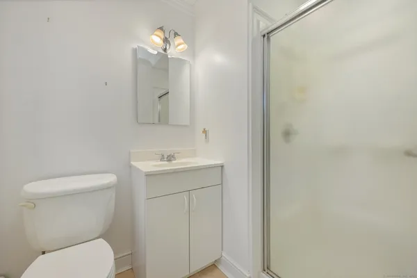 a bathroom with a toilet sink vanity and mirror
