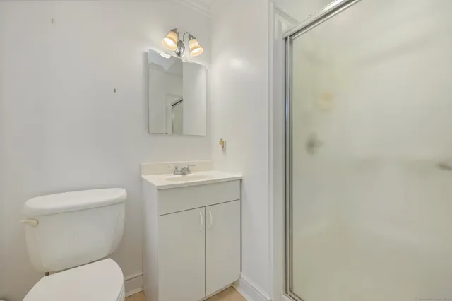 a bathroom with a toilet sink vanity and mirror