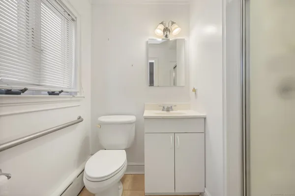 a bathroom with a toilet a sink a mirror and vanity