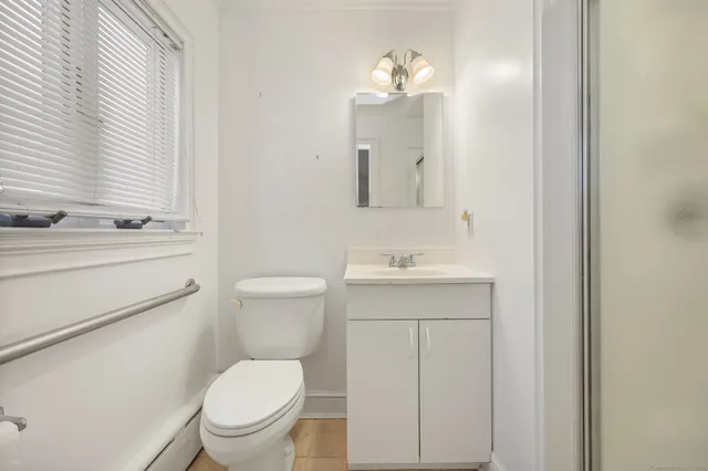 a bathroom with a toilet a sink a mirror and vanity