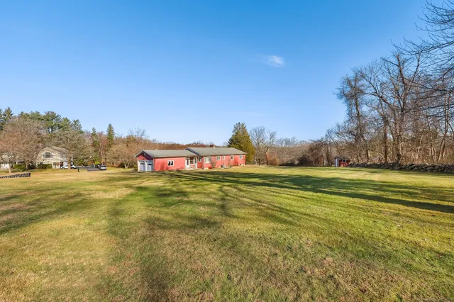 a front view of a house with a yard and trees