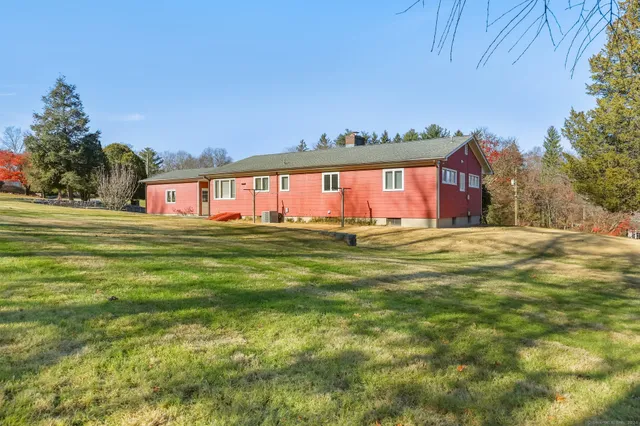 a front view of house with yard and trees in the background