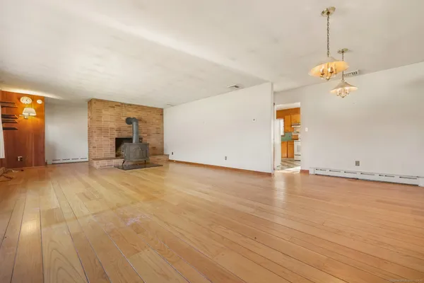 an empty room with wooden floor and ceiling fan