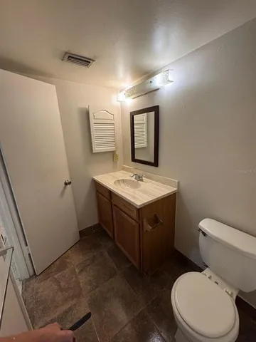 a bathroom with a toilet a sink and mirror