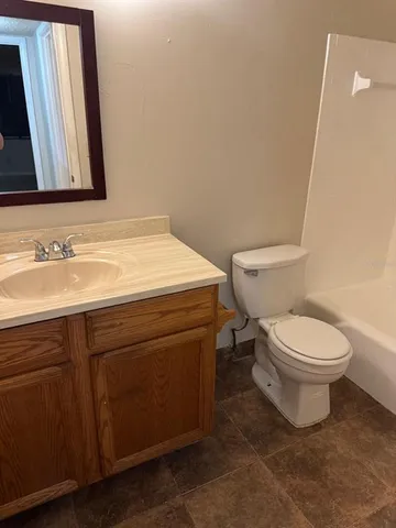 a bathroom with a toilet sink and mirror