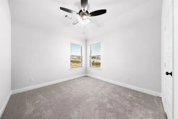 an empty room with fan and windows