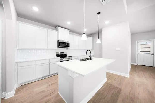 a kitchen with counter top space a sink stainless steel appliances and cabinets