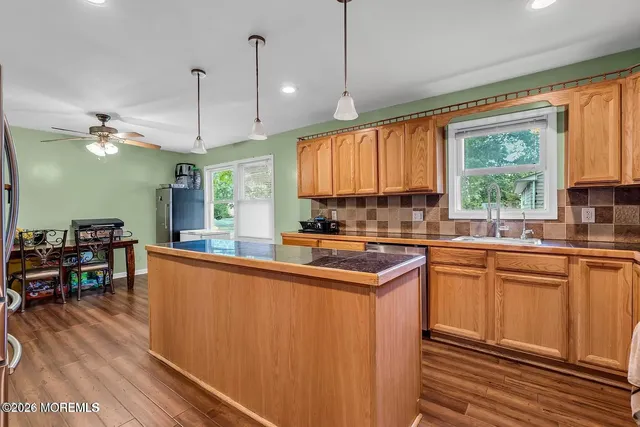 a kitchen with stainless steel appliances granite countertop sink stove and wooden floor