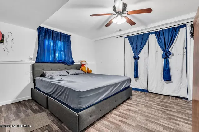 a bed sitting in a spacious bedroom next to a window