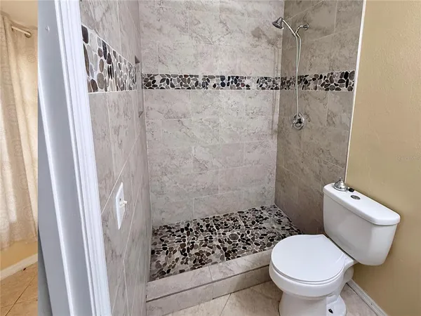 a white toilet sitting next to a shower curtain