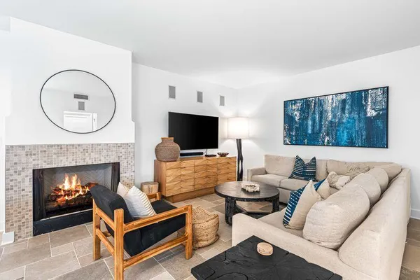 a living room with furniture a flat screen tv and a fireplace