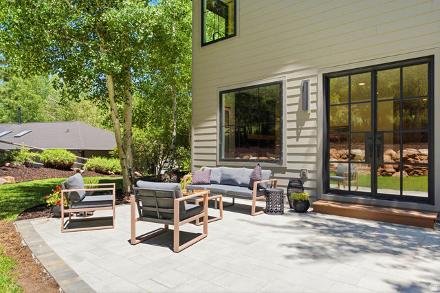 3027 Homestead Road Park City, UT 84098 - Photo 57 of 62 Expansive paver patio with a wood-tone step, black-grid glass doors, and horizontal siding