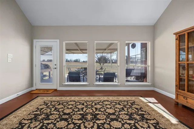 a view of a window and an empty room with wooden floor