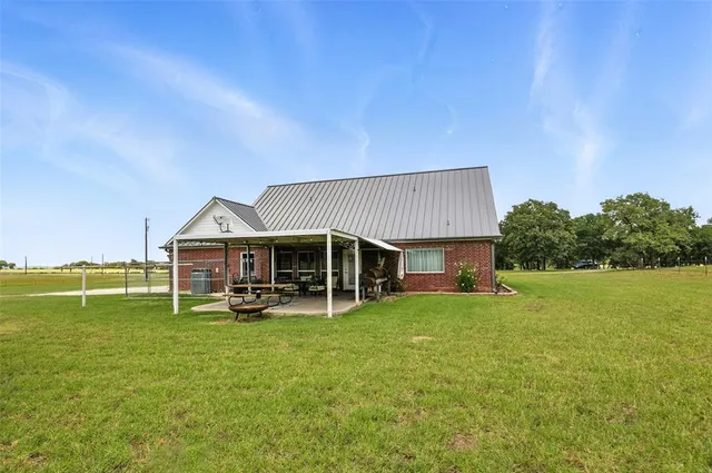 a view of a house with a big yard and sitting area