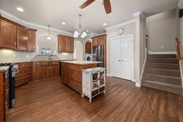 a kitchen with wooden floors and white cabinets