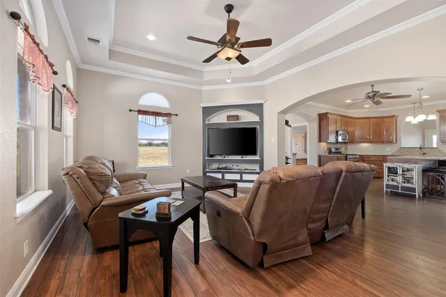 a living room with furniture a flat screen tv and kitchen view