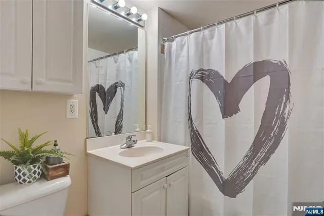 a bathroom with a sink a mirror and a shower curtain