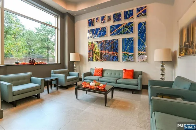 a living room with furniture a bookshelf and a window