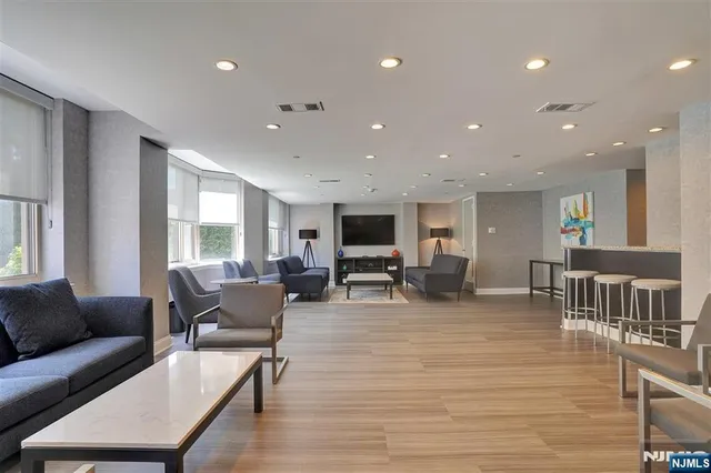 a living room with furniture flat screen tv and couches