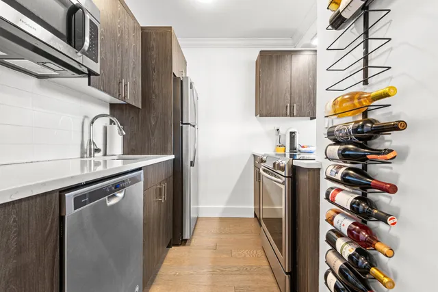 a kitchen with stainless steel appliances granite countertop a sink and a refrigerator