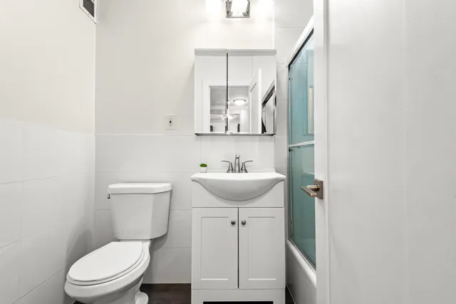 a bathroom with a toilet sink and mirror