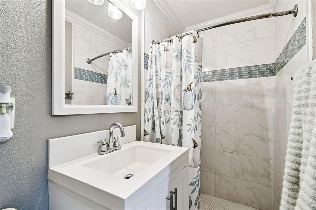5831 1st Avenue New Port Richey, FL 34652 - Photo 16 of 22 a bathroom with a sink a mirror and a shower