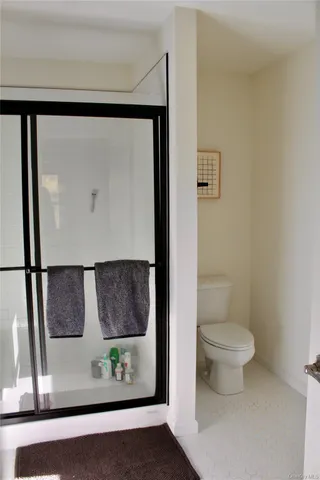 a bathroom with a toilet and a painting on the wall