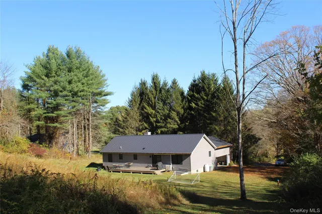 a aerial view of a house next to a yard with large trees