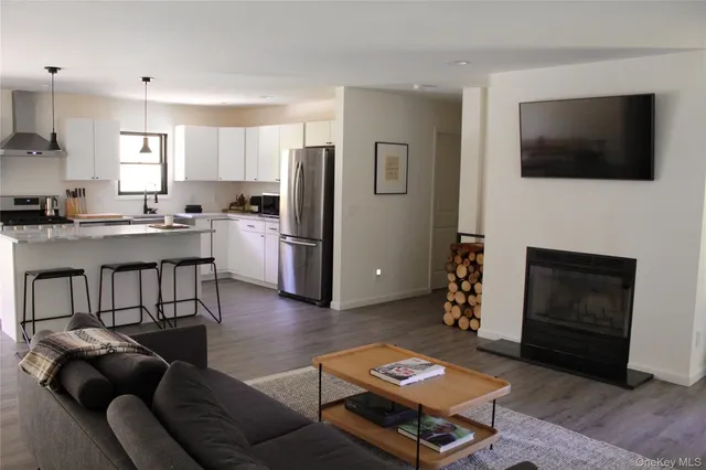a living room with furniture a flat screen tv and a fireplace