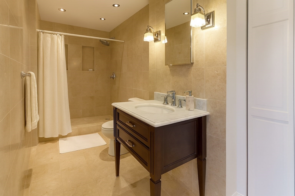 151 Tremont Street, Unit 24U Boston, MA 02111 - Photo 16 of 29 a bathroom with a sink vanity and a mirror