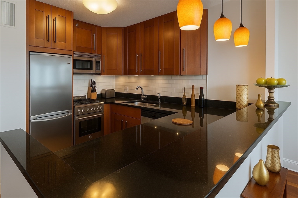 151 Tremont Street, Unit 24U Boston, MA 02111 - Photo 7 of 29 a kitchen with granite countertop a sink a stove and cabinets