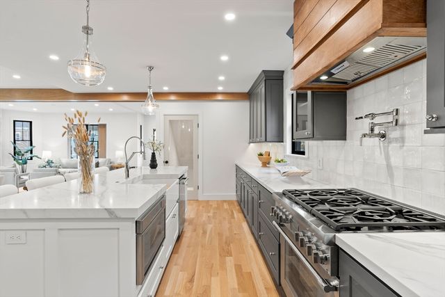 a large kitchen with stainless steel appliances granite countertop a large stove a sink dishwasher and cabinets with wooden floor