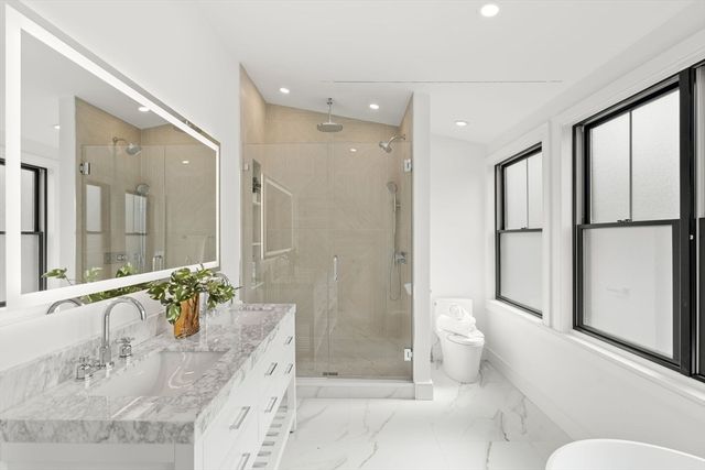 a bathroom with a tub sink and mirror