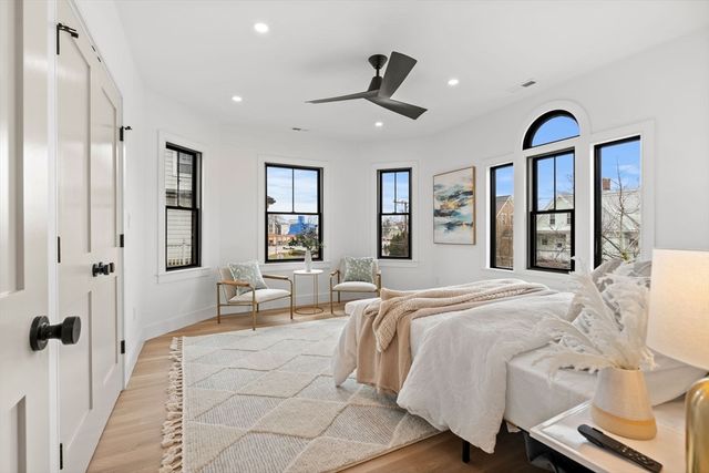 a spacious bedroom with a large bed and a chandelier