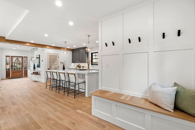 a kitchen with stainless steel appliances kitchen island granite countertop a refrigerator a stove and white cabinets with wooden floor