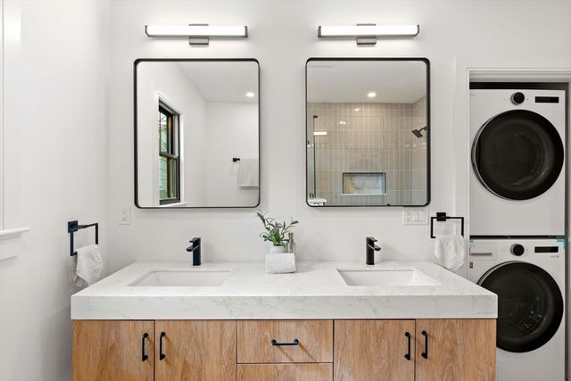 a bathroom with double vanity a mirror and a sink