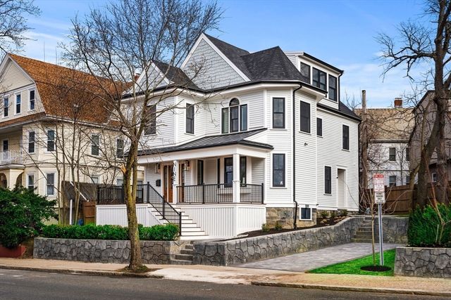 a view of a white building among the street with palm trees