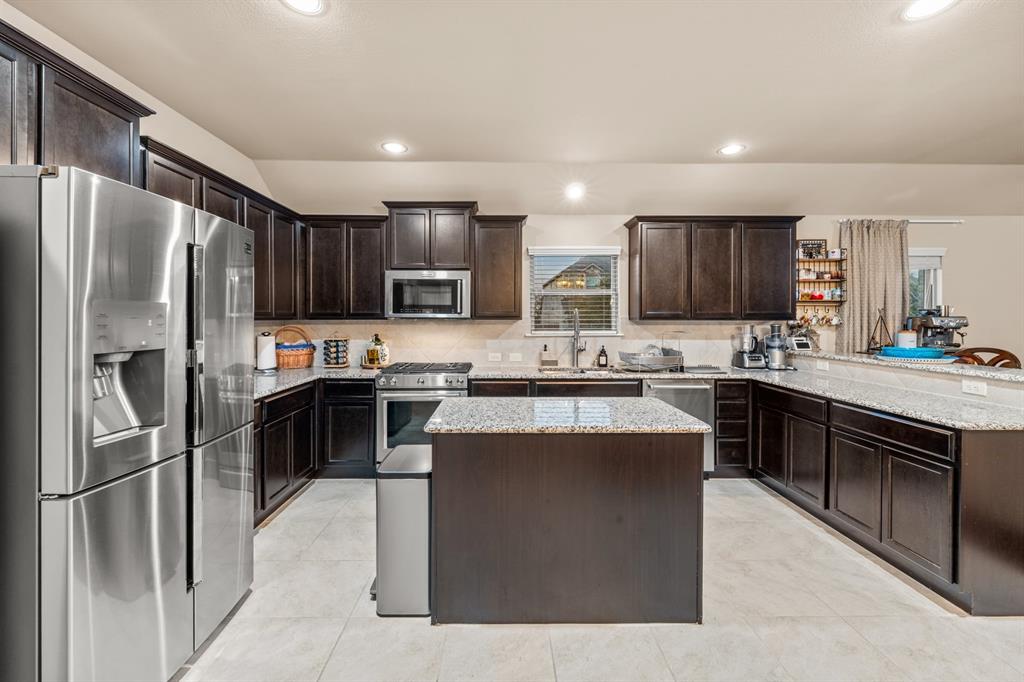 201 Whitman Drive McKinney, TX 75072 - Photo 11 of 33 a kitchen with stainless steel appliances granite countertop a refrigerator stove microwave and sink