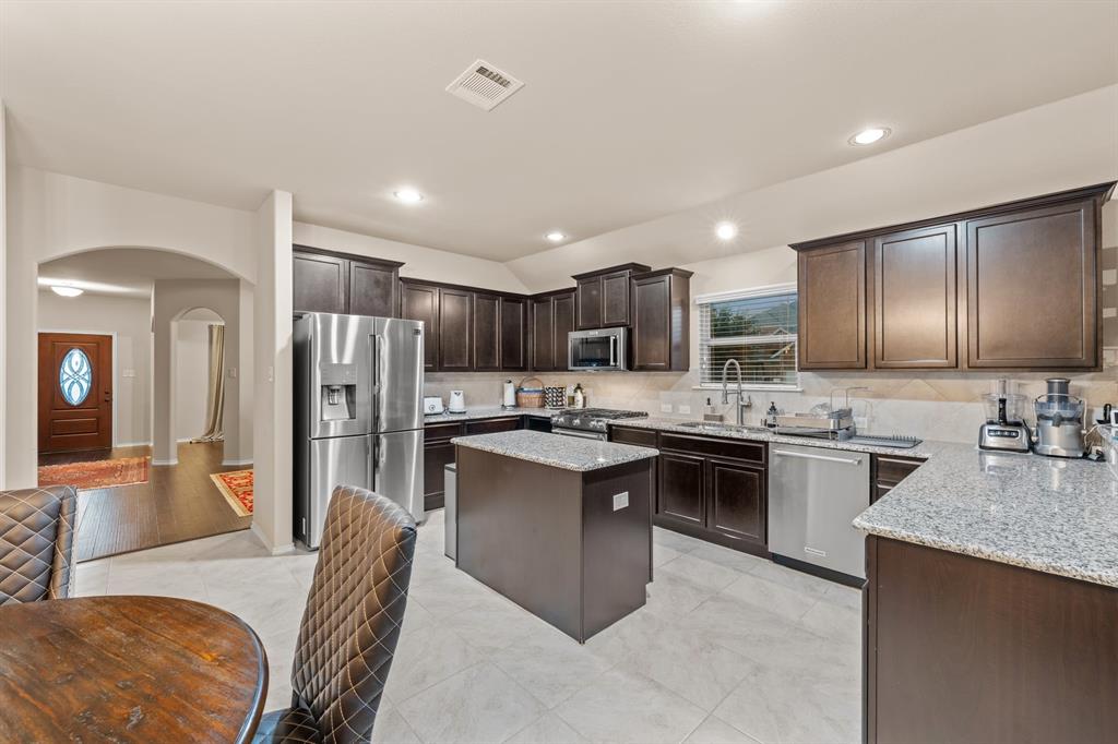 201 Whitman Drive McKinney, TX 75072 - Photo 13 of 33 a kitchen with refrigerator a sink and chairs