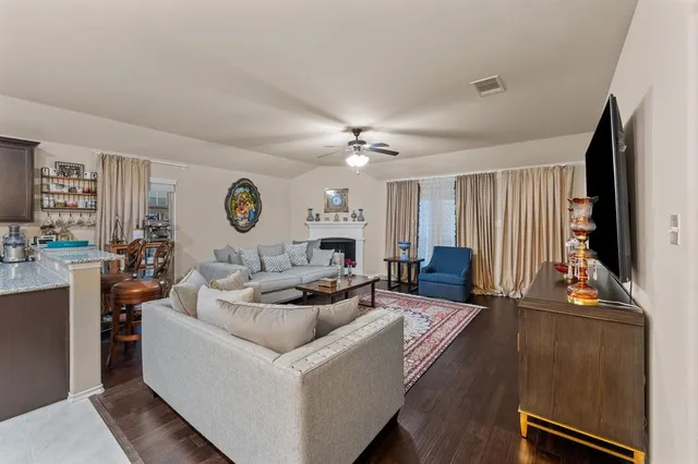 a living room with furniture a fireplace and a large window