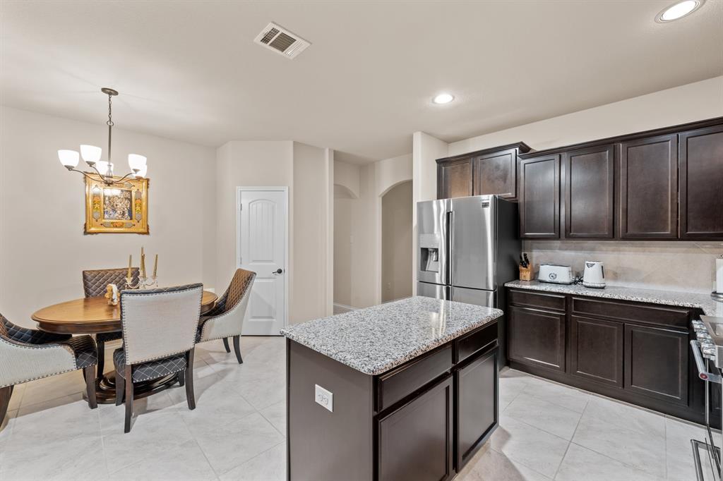 201 Whitman Drive McKinney, TX 75072 - Photo 15 of 33 a kitchen that has a kitchen island wooden cabinets and stainless steel appliances