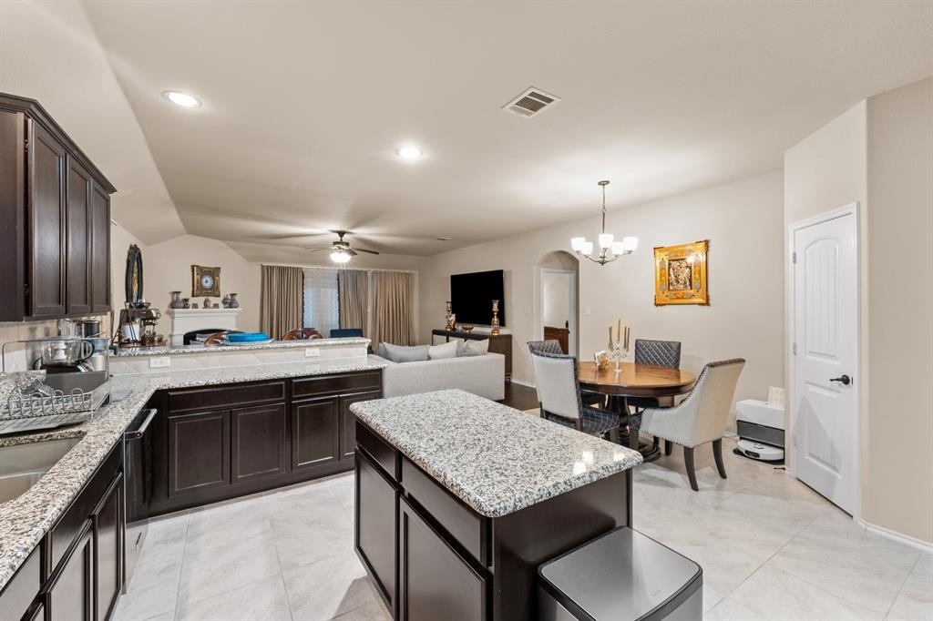 201 Whitman Drive McKinney, TX 75072 - Photo 33 of 33 a kitchen with a stove a sink dishwasher a dining table and chairs with wooden floor