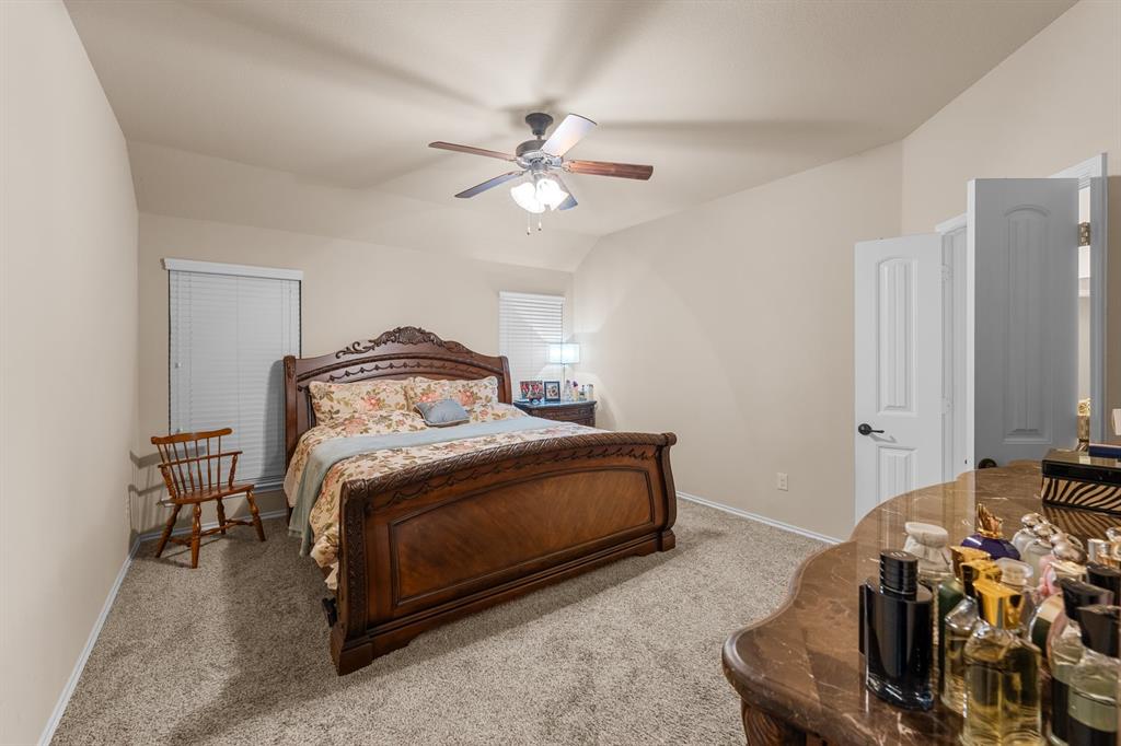 201 Whitman Drive McKinney, TX 75072 - Photo 24 of 33 a bedroom with a bed and a chandelier