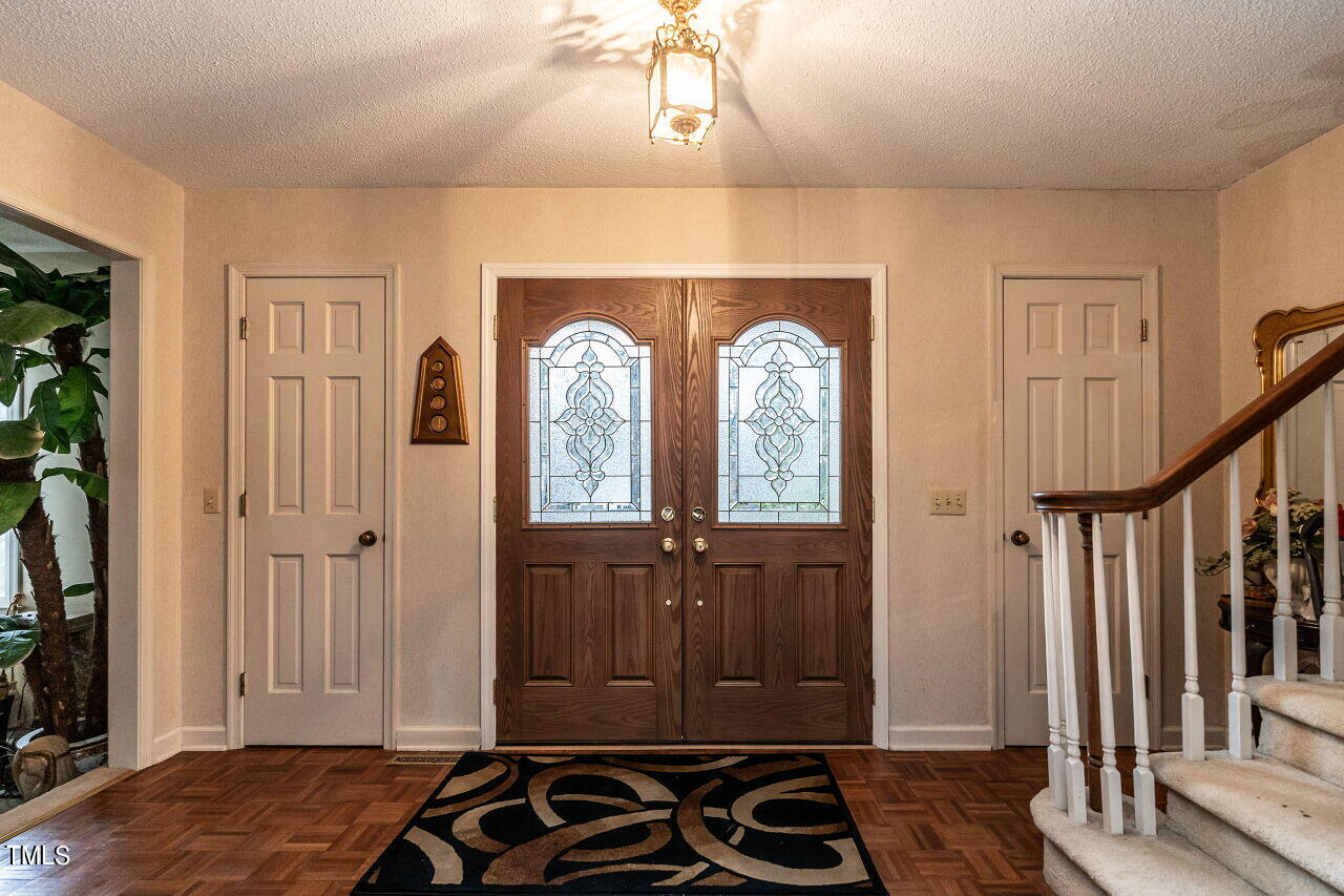 609 Queensferry Road Cary, NC 27511 - Photo 3 of 12 a bedroom with a bed and a flat tv screen