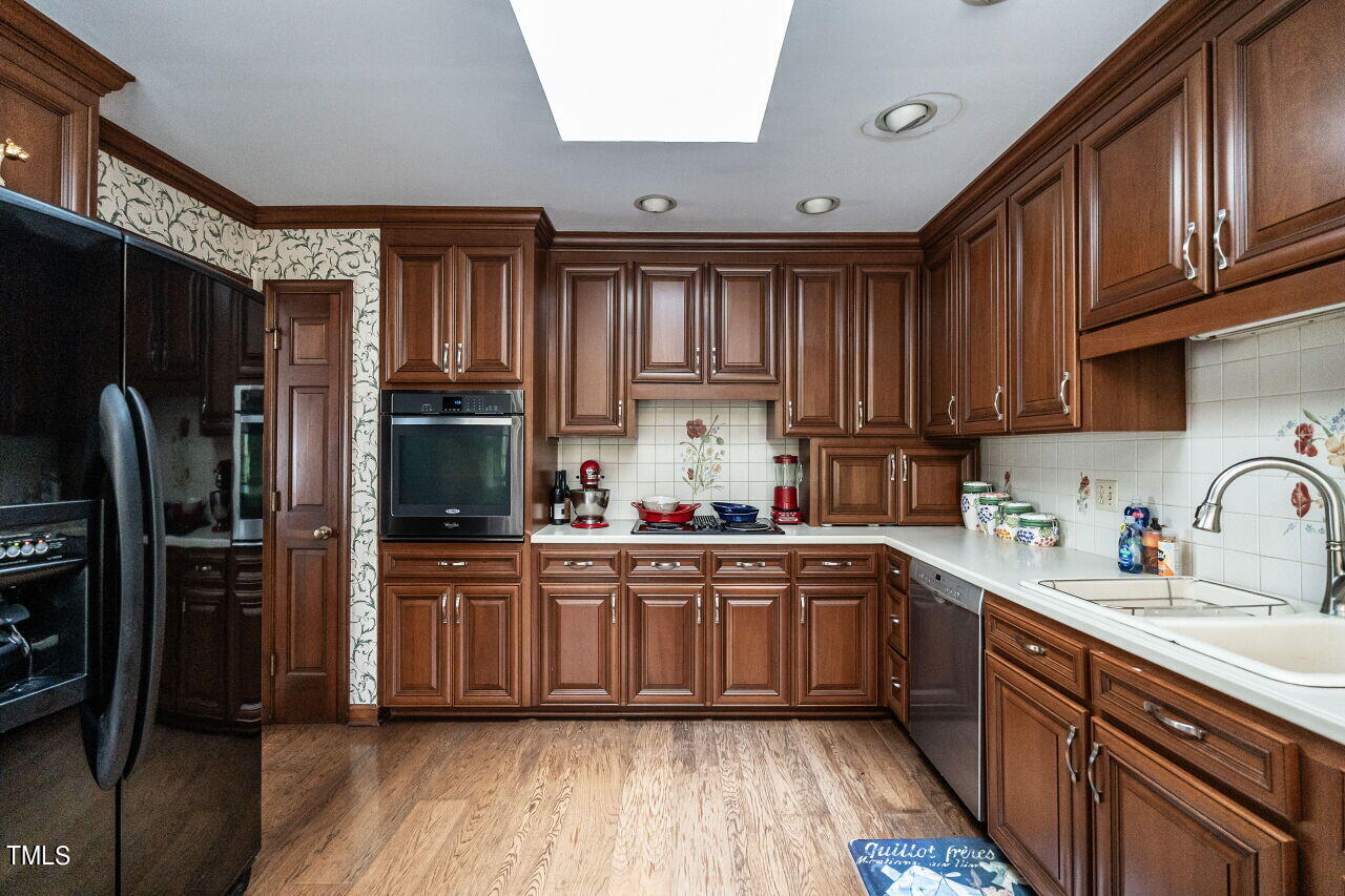 609 Queensferry Road Cary, NC 27511 - Photo 7 of 12 a kitchen with kitchen island granite countertop a sink stainless steel appliances and cabinets