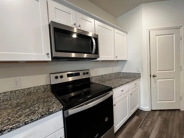 a kitchen with stainless steel appliances granite countertop a stove microwave and sink