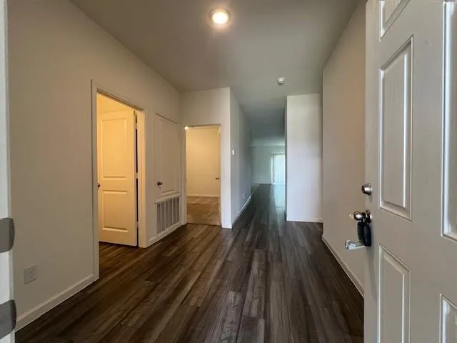 a view of a hallway with wooden floor and staircase
