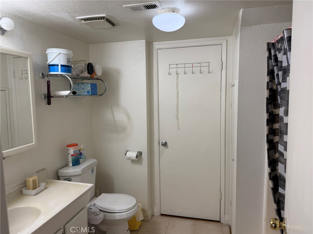 11829 Ferris Road, Unit E El Monte, CA 91732 - Photo 2 of 10 a bathroom with a sink a toilet and a mirror