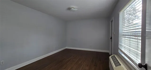 a view of a room with wooden floor and windows