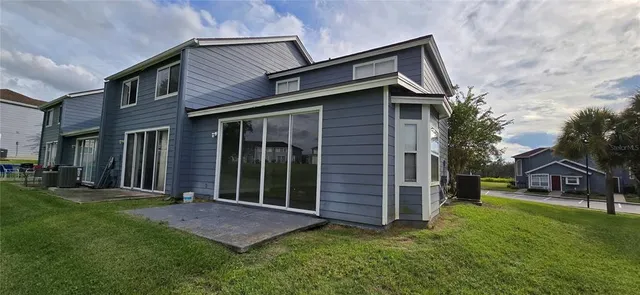 a view of a house with a small yard and wooden fence